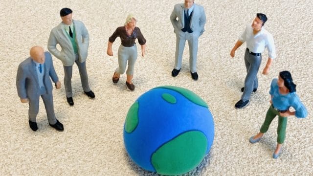 地球の小さな模型を囲むように、6体の多様なビジネスパーソンのミニチュアが円形に並んでおり、グローバルなチームワークとコラボレーションを象徴している。また、帰国子女などグローバルな視点を持つ者が世界を目指して成長していくことを表現している。